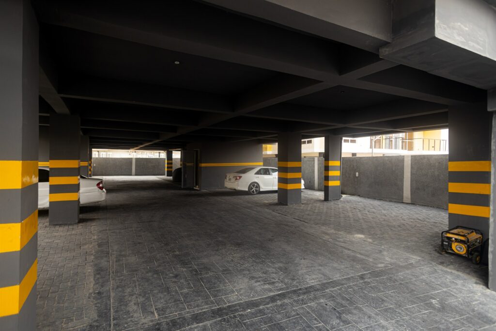 Brum Height 4: Covered parking area with marked columns and parked vehicles